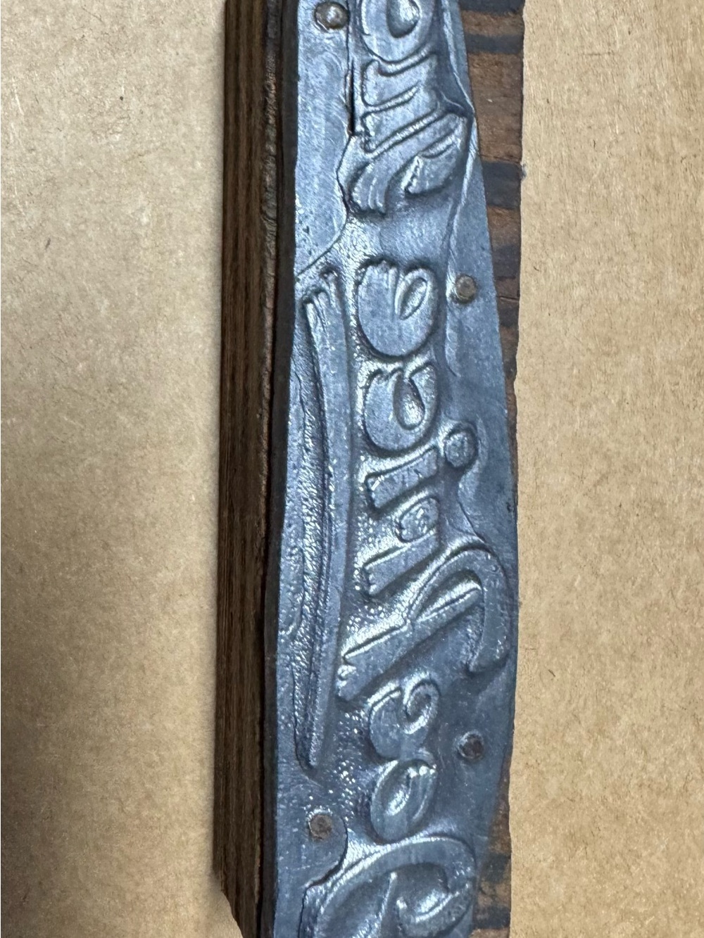 vintage metal letterpress printing block mounted on a wooden base